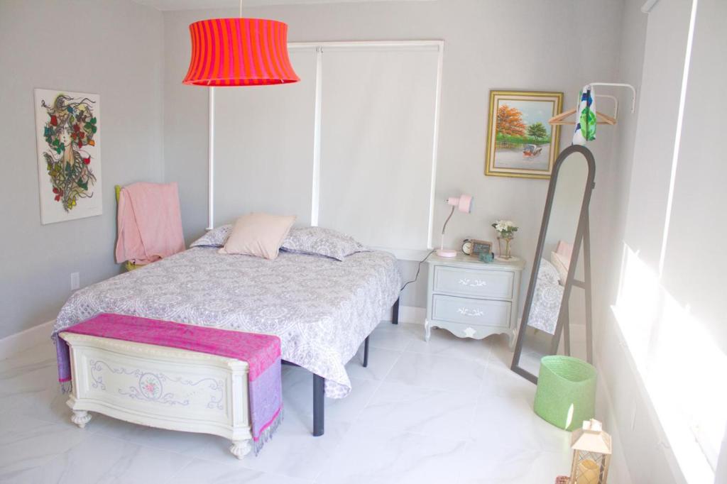 Dormitorio pequeño con cama y lámpara roja en Colorful and Luminous Suite near MIA - 4G en Miami