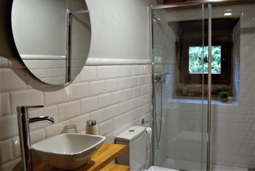 a bathroom with a sink and a shower with a mirror at Apartamentos El Abertal in Navedo