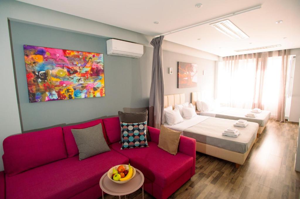 salon z kanapą i łóżkiem w obiekcie Ermou Downtown Studios by Hospitality Box w Atenach