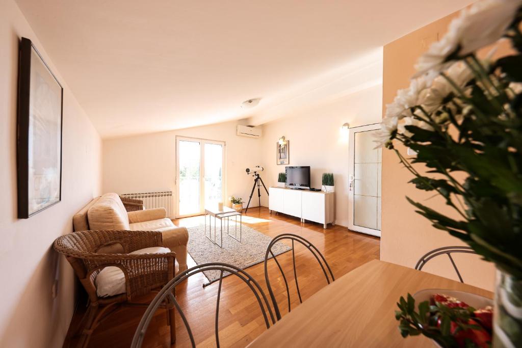 uma sala de estar com um sofá e uma mesa em Apartment and Rooms Santini em Sveti Filip i Jakov