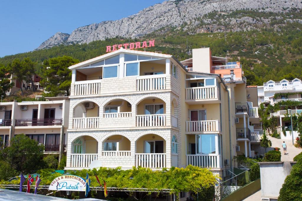 a hotel on the side of a mountain at Apartmani Putnik in Baška Voda