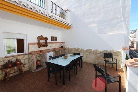 een woonkamer met een tafel en een open haard bij Casa María en el centro Nerja in Nerja