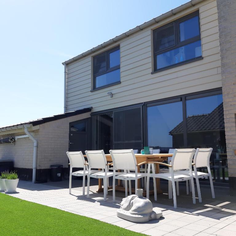 a wooden table and chairs in front of a house at Maison Maritime in Middelkerke