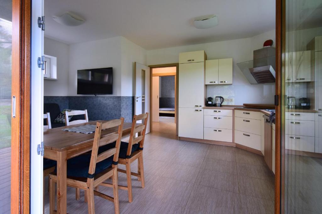 a kitchen and dining room with a table and chairs at Bungalov v Beskydech in Frenštát pod Radhoštěm