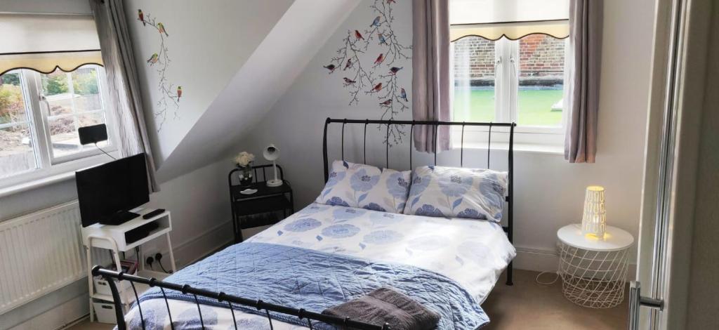 1 dormitorio con 1 cama con sábanas azules y blancas en House on the Corner B&B en Didcot