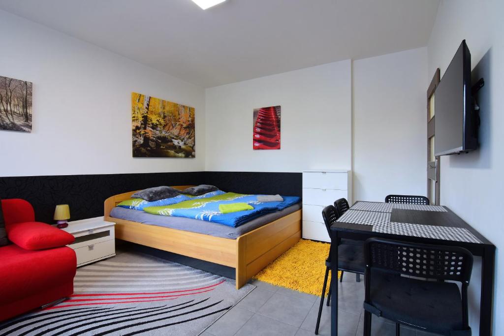 Schlafzimmer mit einem Bett, einem Schreibtisch und einem Stuhl in der Unterkunft Apartman Veronika in Trojanovice