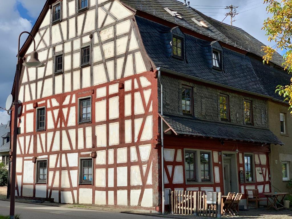 ein altes Haus mit einem roten und weißen Gebäude in der Unterkunft Altes Zehnthaus Geierlay in Mittelstrimmig