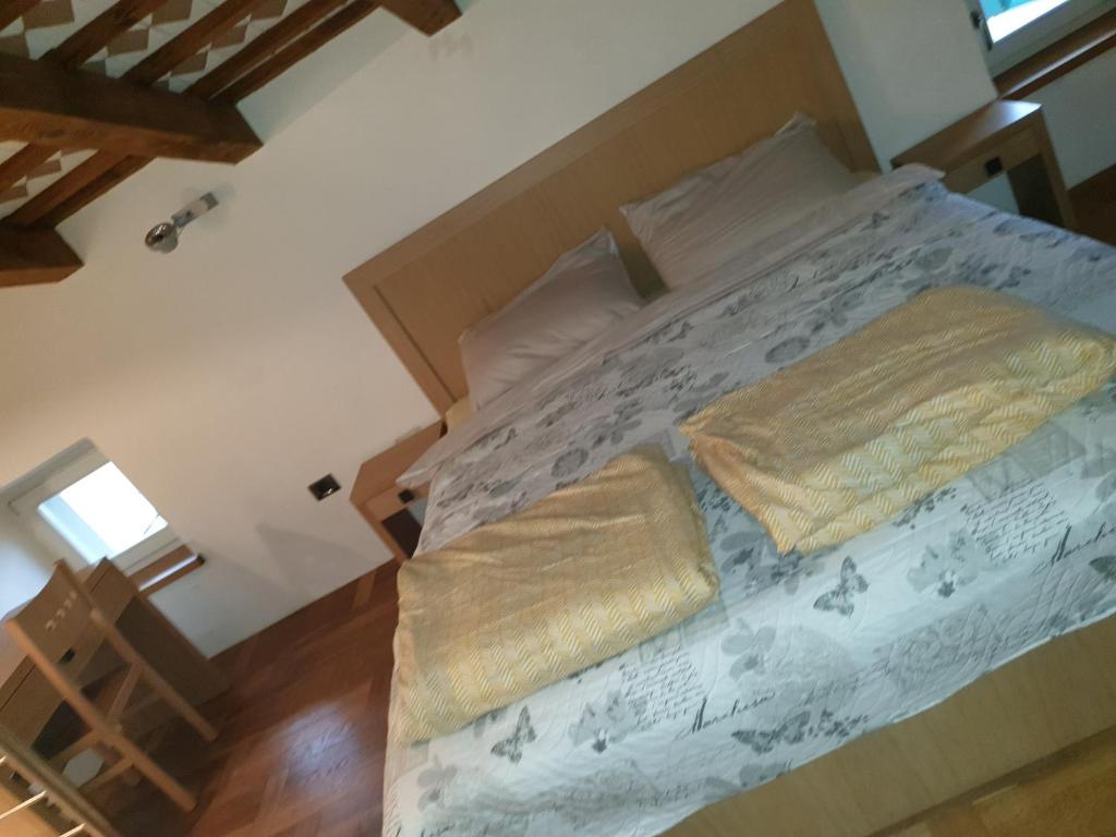 a large bed with two pillows on it in a room at Šmartno Apartmaji Goran in Kojsko