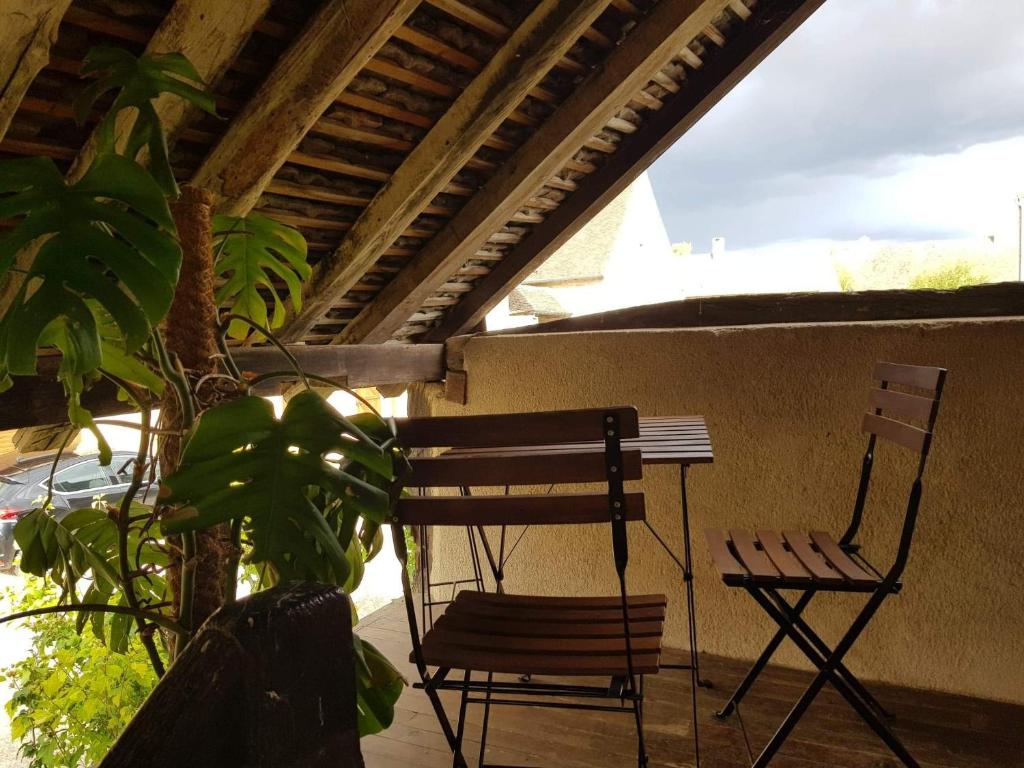 2 Stühle und ein Tisch auf einer Veranda in der Unterkunft Gite l'Escale in Gigny-sur-Saône