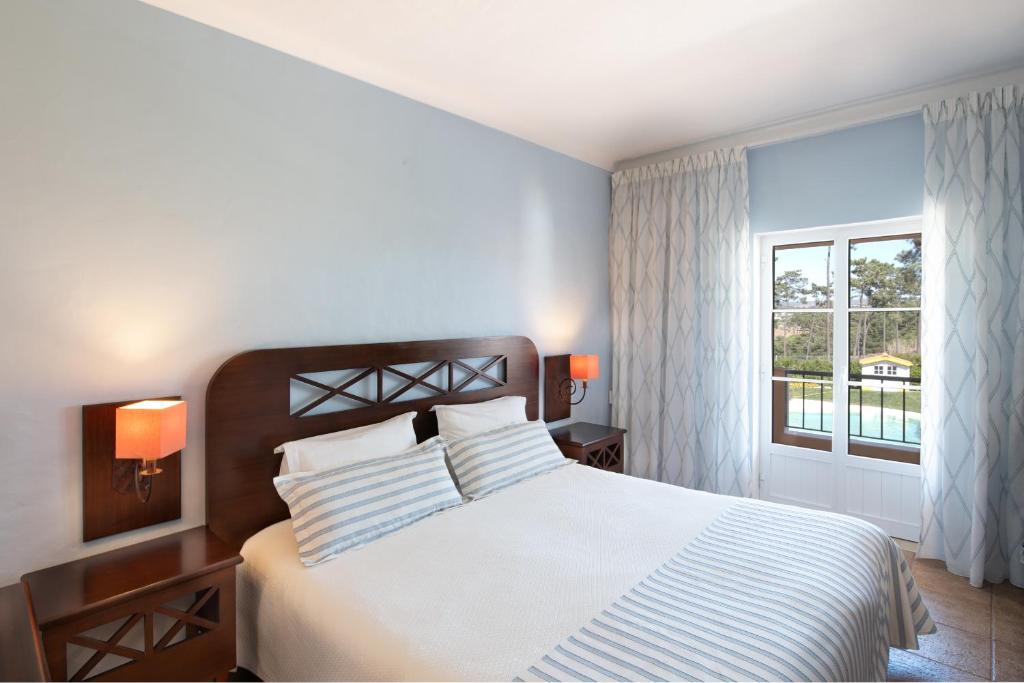 a bedroom with a large bed and a window at Hotel Rural Monte da Leziria in Santo André