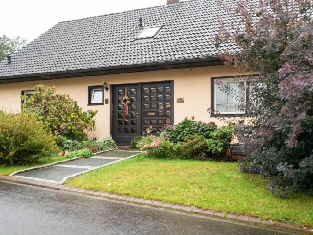 a house with a black door and a yard at Holiday home in Kyllburg Eifel near the forest in Kyllburg