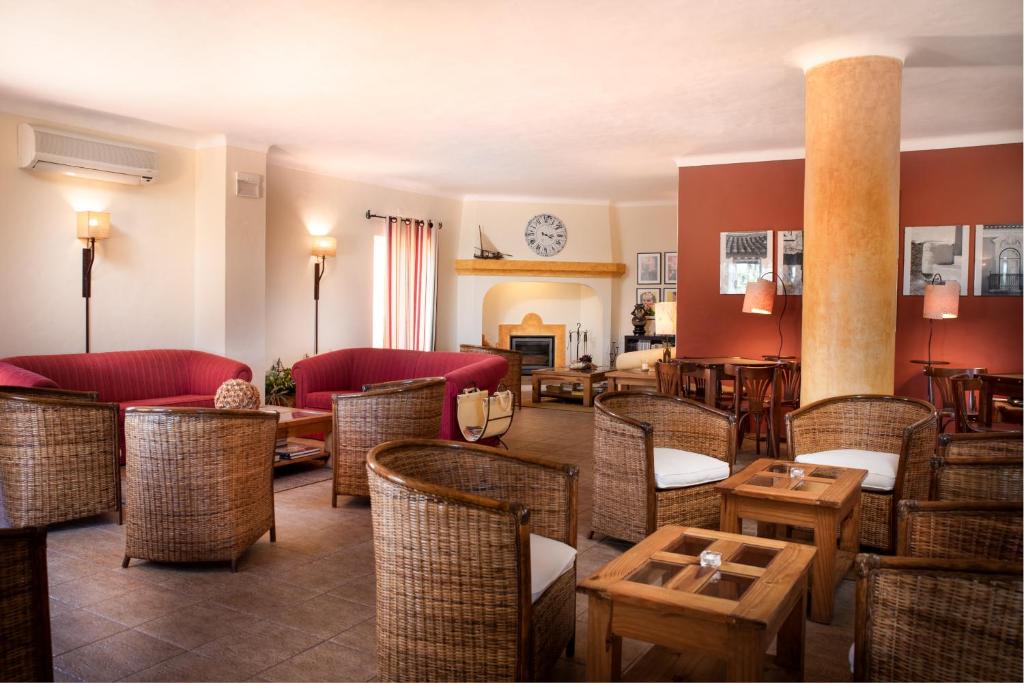 un restaurant avec des tables et des chaises en osier dans l'établissement Hotel Rural Monte da Leziria, à Santo André