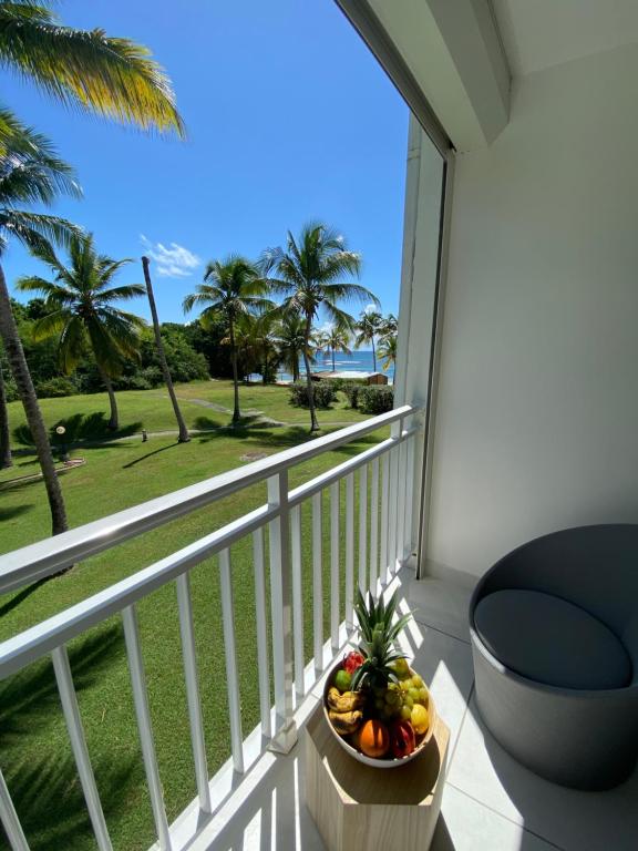 - un bol de fruits sur un balcon avec vue sur l'océan dans l'établissement Iguana studio vue mer avec cuve, à Saint-François