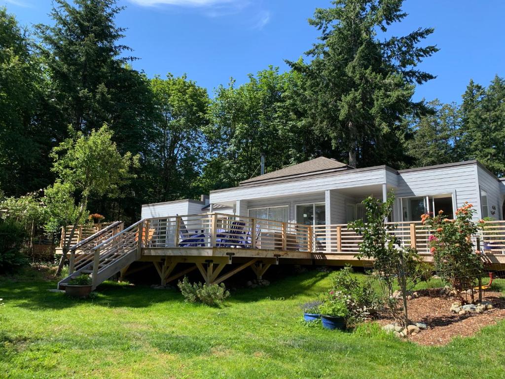 a mobile home with a large deck in the yard at Forest by the Sea Rentals in Merville