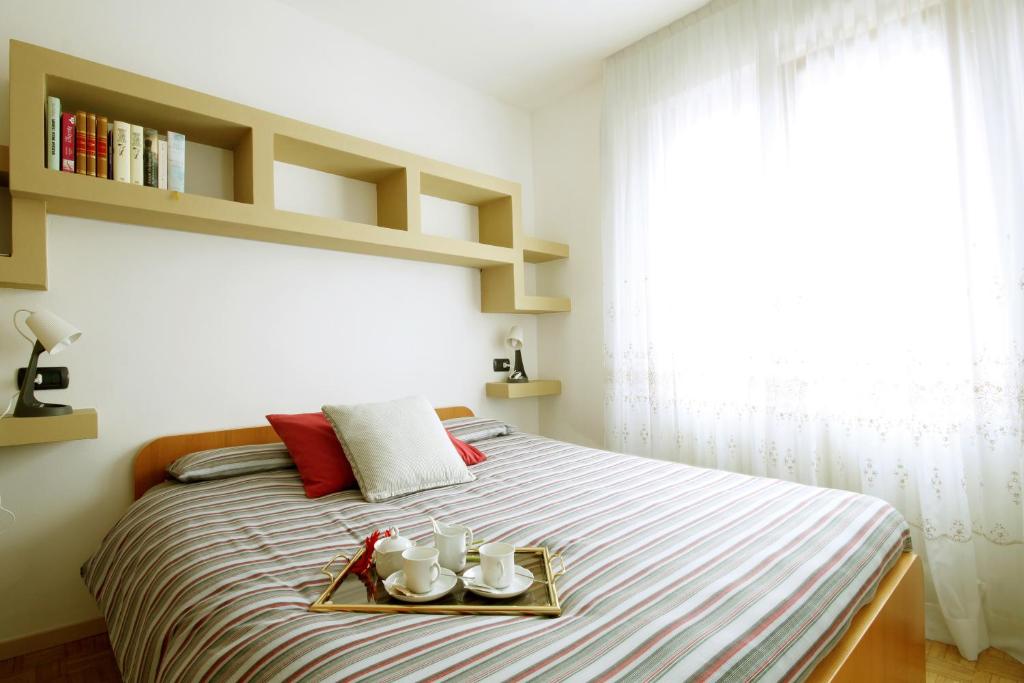 Un dormitorio con una cama y una bandeja con dos platos. en Belcolle, il bello della tranquillità, en Chiavenna