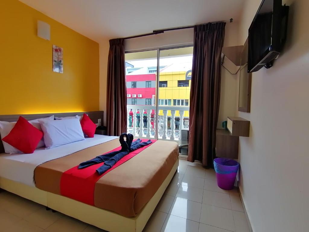 a hotel room with a bed and a large window at Yellow Mansion Hotel Melaka Raya in Melaka