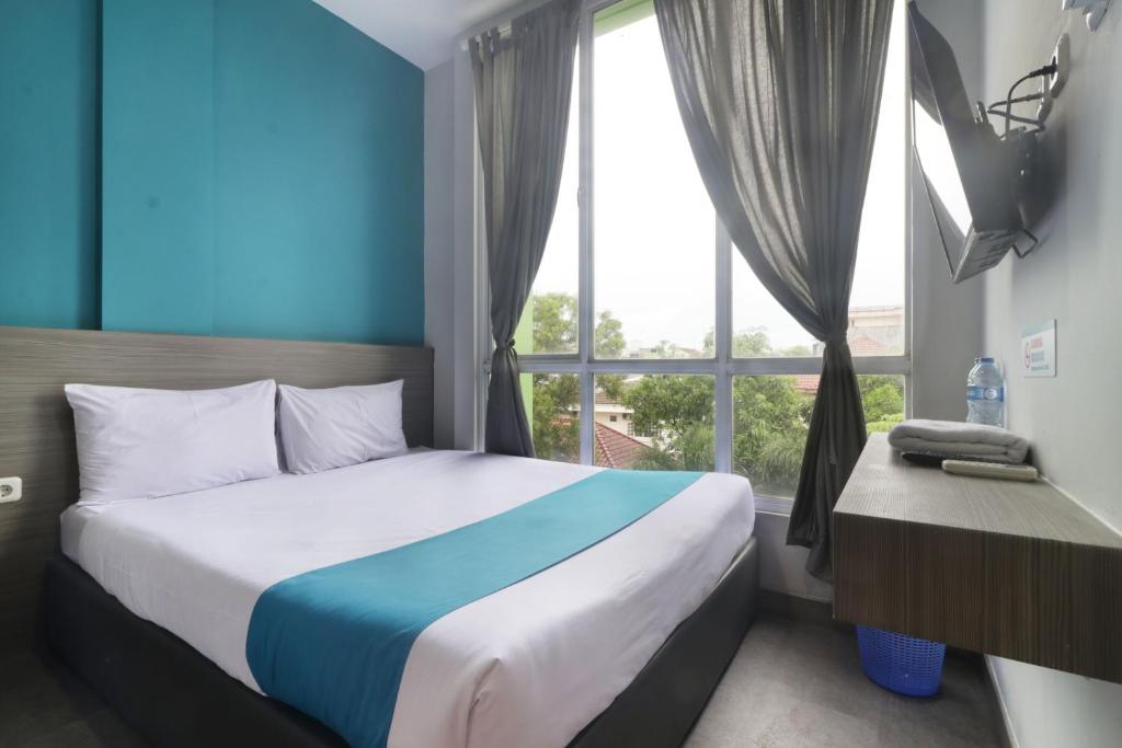 ein Schlafzimmer mit einem Bett und einem großen Fenster in der Unterkunft Sambina in Jakarta
