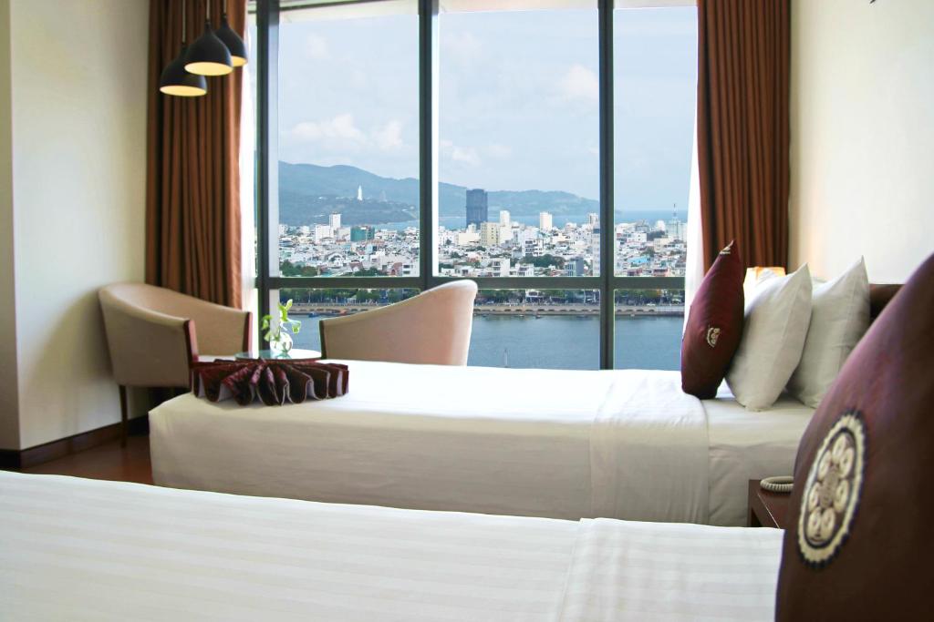 Postel nebo postele na pokoji v ubytování Da Nang Han River Hotel
