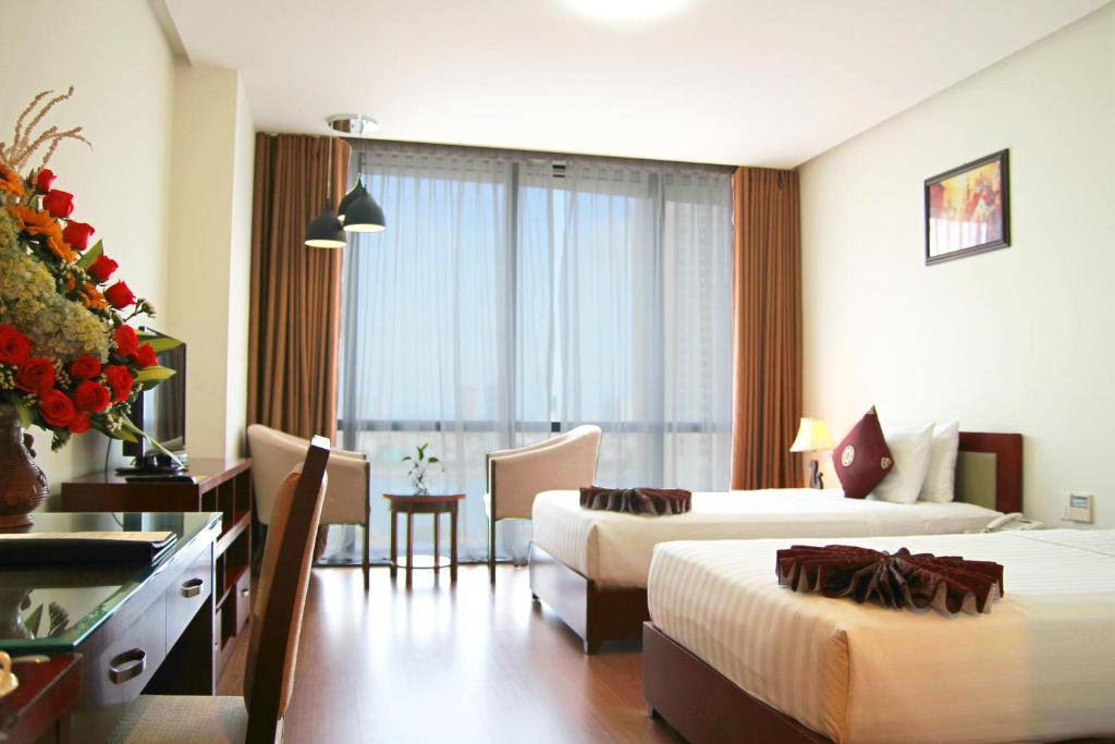 Postel nebo postele na pokoji v ubytování Da Nang Han River Hotel