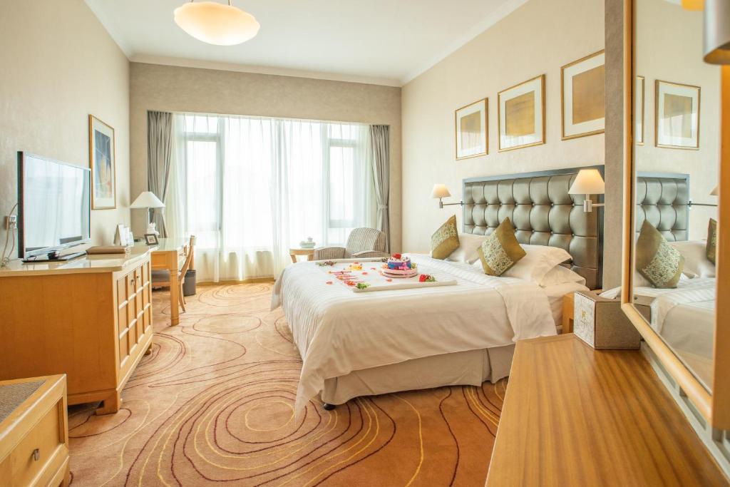 A bed or beds in a room at Shantou Junhua Haiyi Hotel