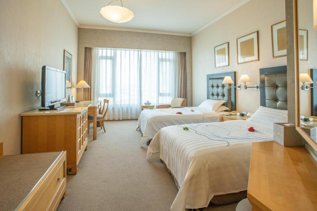 Postel nebo postele na pokoji v ubytování Shantou Junhua Haiyi Hotel