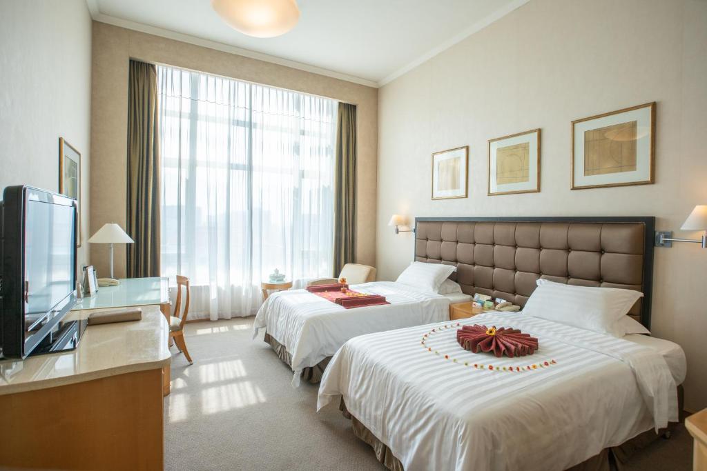 Postel nebo postele na pokoji v ubytování Shantou Junhua Haiyi Hotel