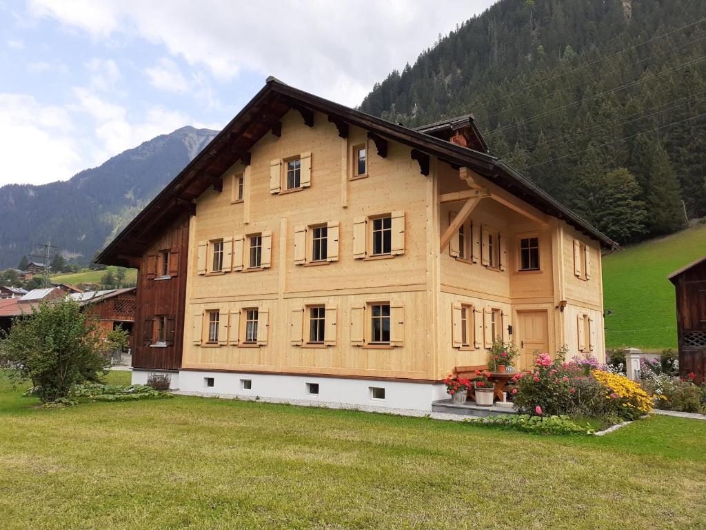 duży drewniany dom na środku pola w obiekcie Ferienhaus Pfeifer w mieście Gaschurn