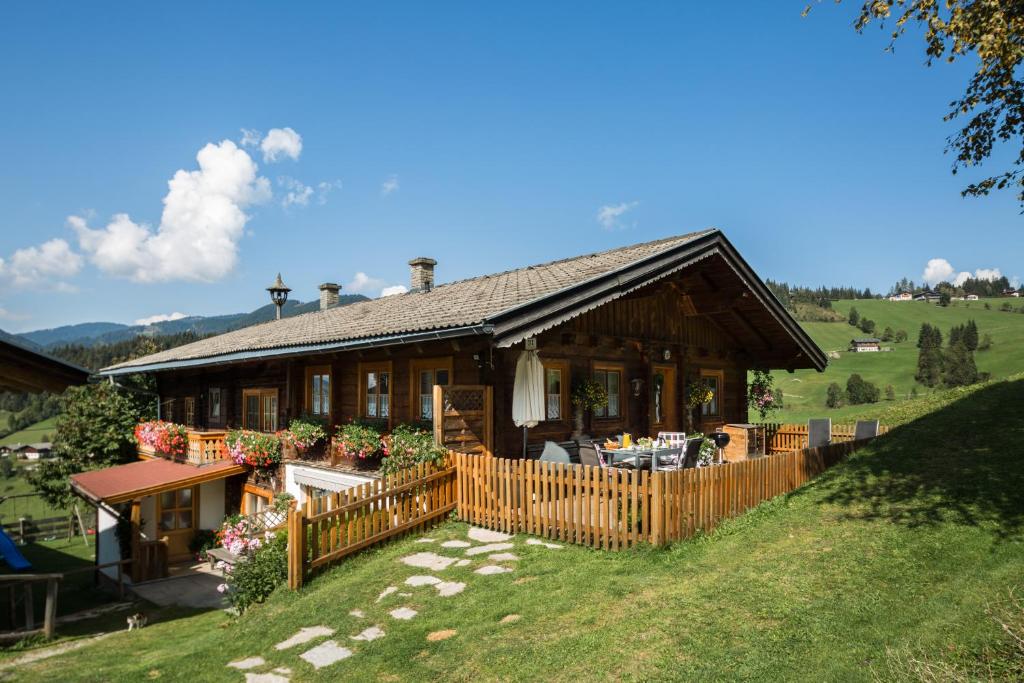 a house on a hill with a wooden fence at DAS "ZwisleggGut" in Wagrain