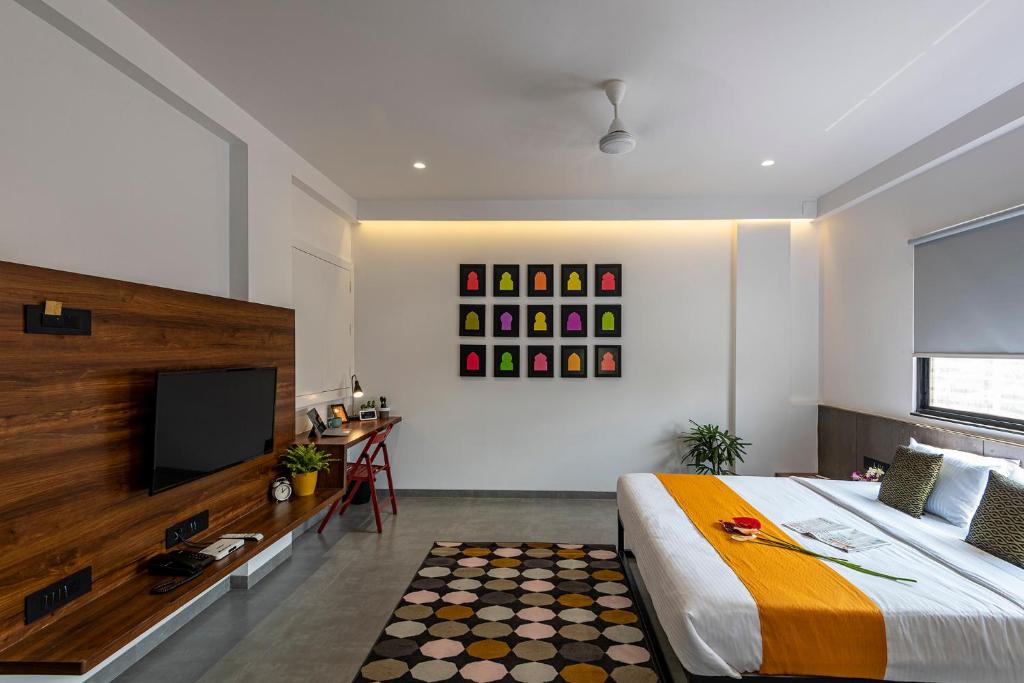 1 dormitorio con 1 cama grande y TV de pantalla plana en The Cult Stay, en Solapur