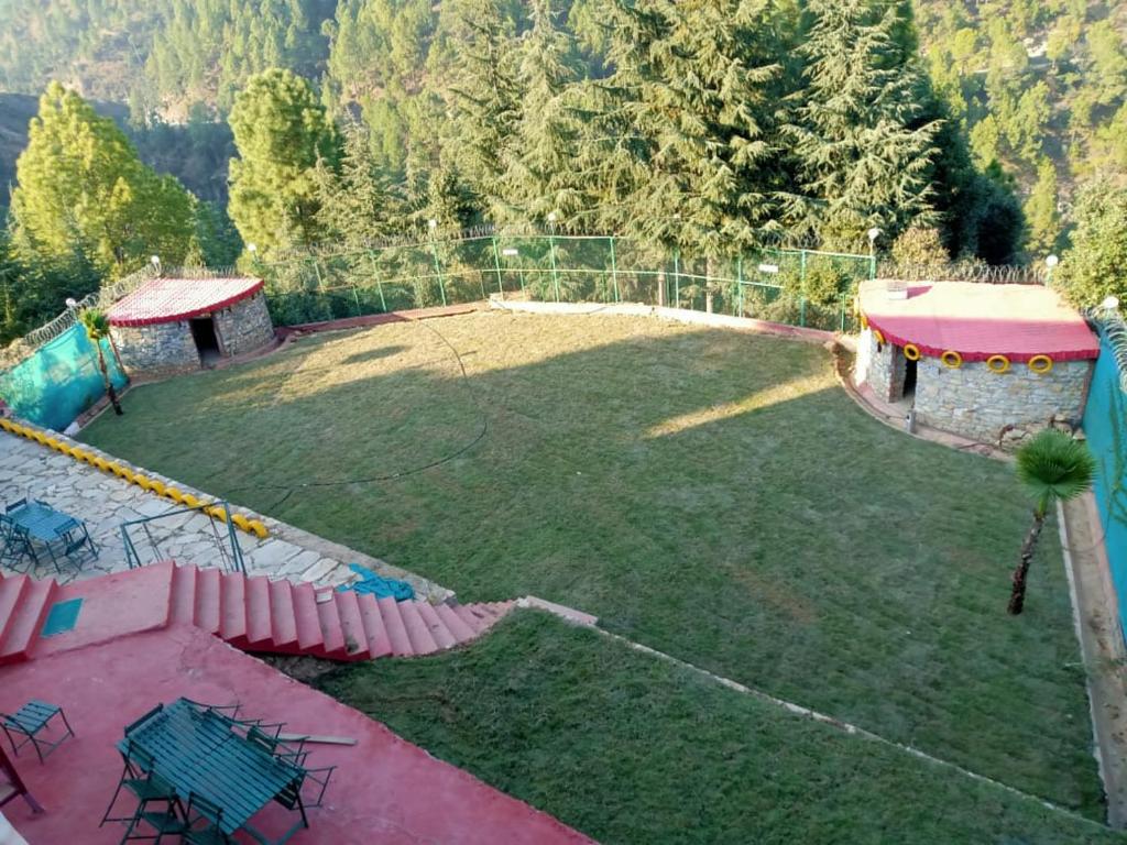 una vista aérea de un gran patio con parque infantil en Tathastu Resort en Mukteswar