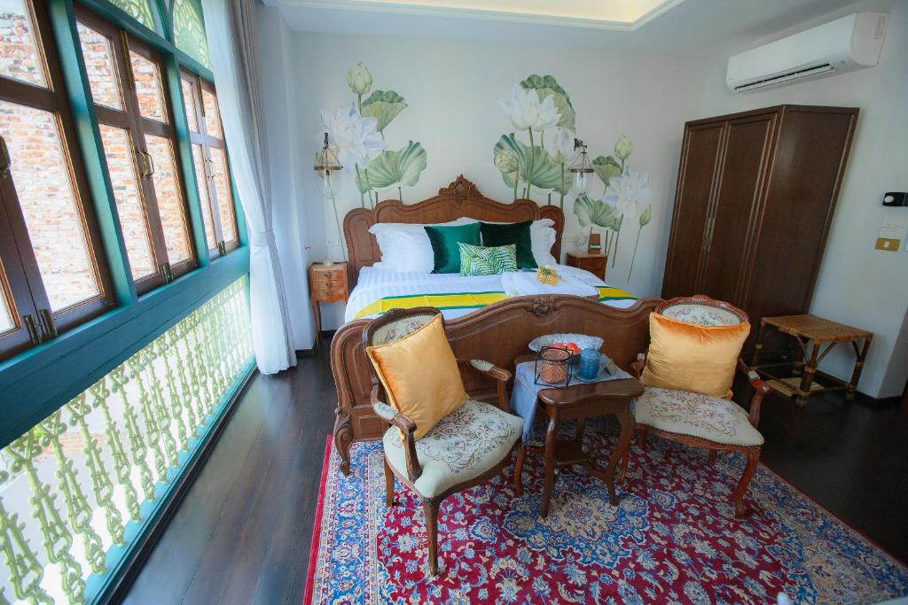 sypialnia z łóżkiem, 2 krzesłami i stołem w obiekcie The Knight House Bangkok w mieście Bangkok