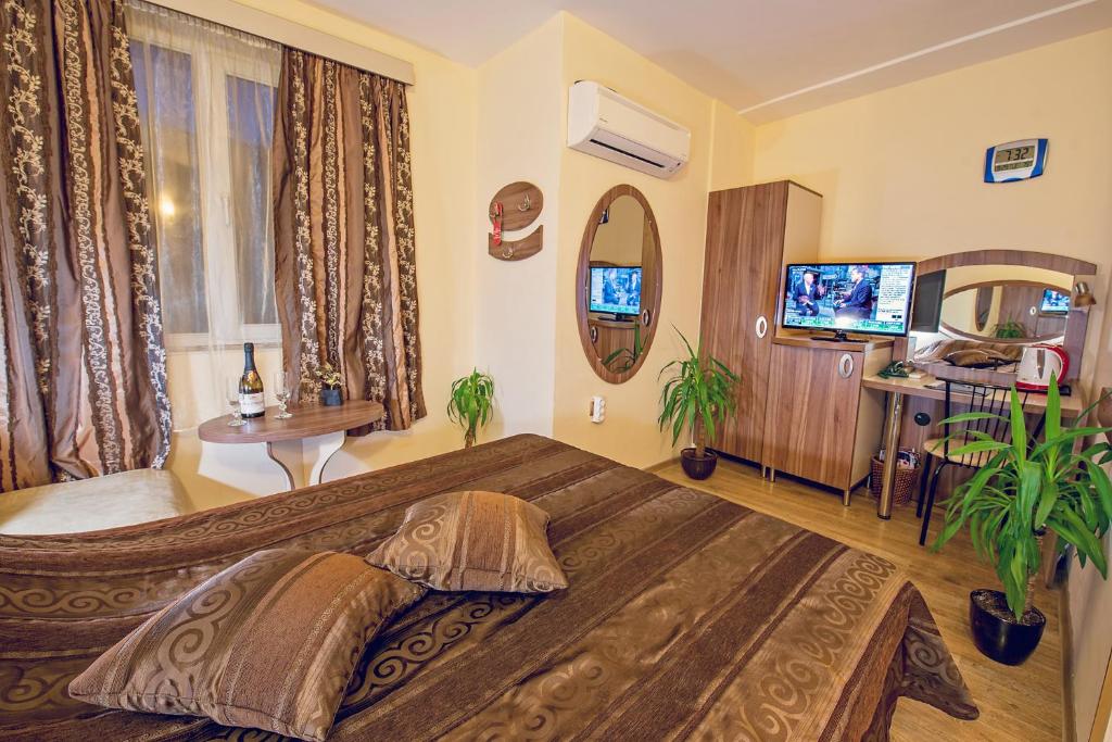 une chambre avec un grand lit et une télévision dans l'établissement Hotel Color, à Varna