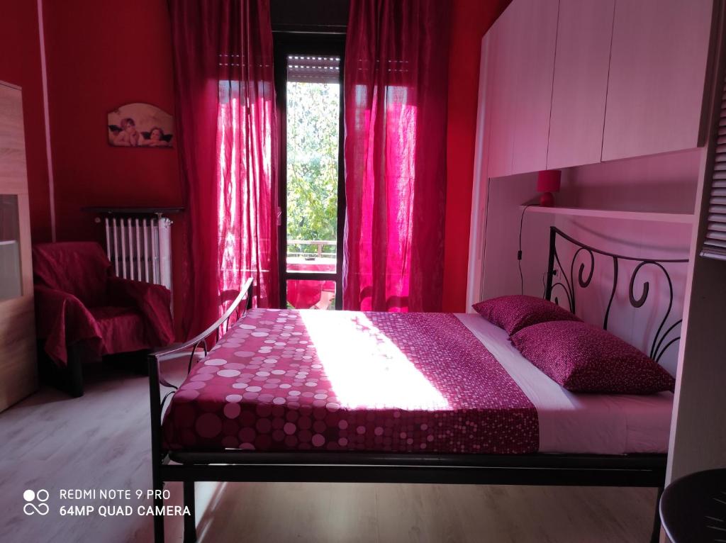 una camera da letto con un letto con tende rosa e una finestra di Beb da Gaia e Giulio a Reno Di Leggiuno