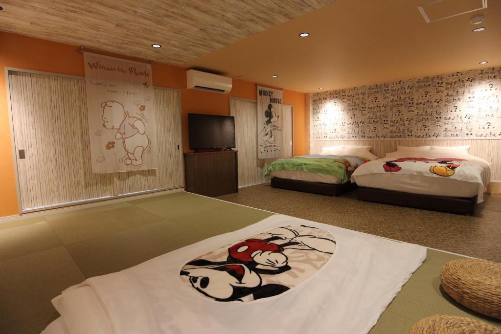 a bedroom with two beds and a flat screen tv at Chiba sta 1min J hotel 2020 Open in Chiba