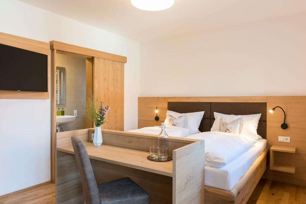 ein Hotelzimmer mit einem Bett, einem Schreibtisch und einem TV in der Unterkunft Gasthof-Pension Brauner Hirsch in Alfeld - Mittelfranken in Alfeld