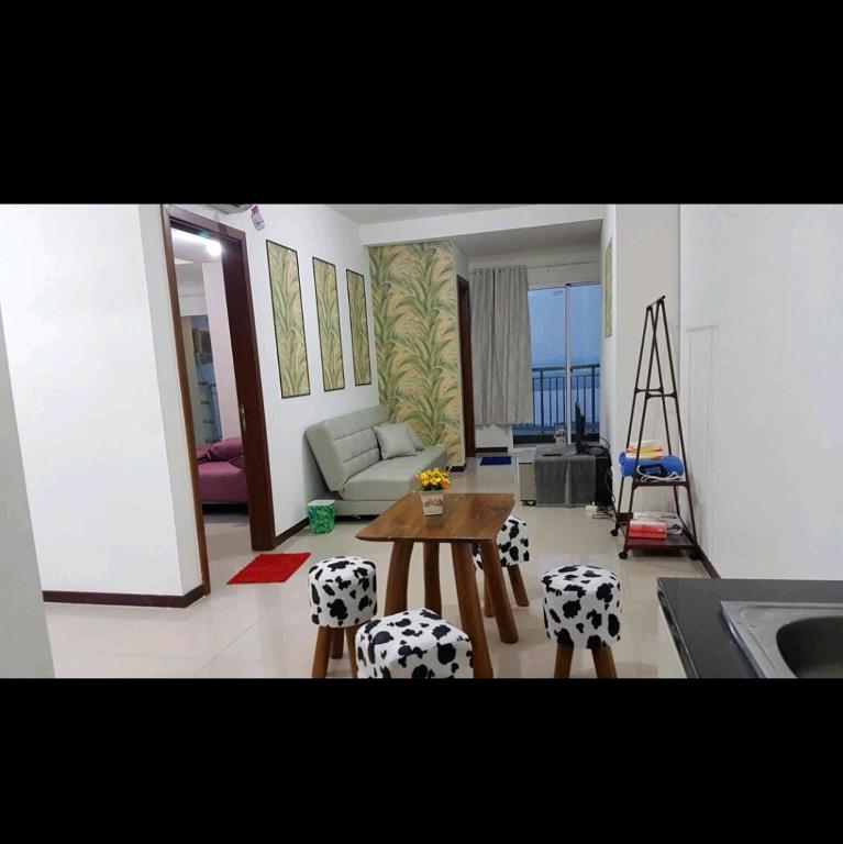 a living room with a table and chairs at 2 BR Jungle Decor Beautiful Sea View Fast Internet Top Of The Mall in Jakarta