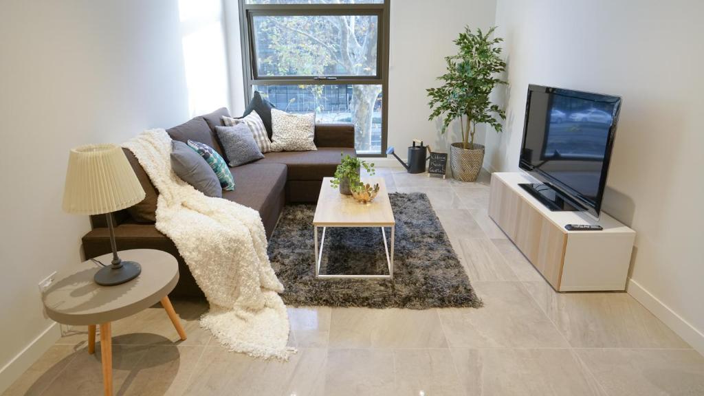 a living room with a couch and a tv at SYDNEY CBD WALK TO DARLING HARBOUR MODERN 1 BED APT NSY188 in Sydney
