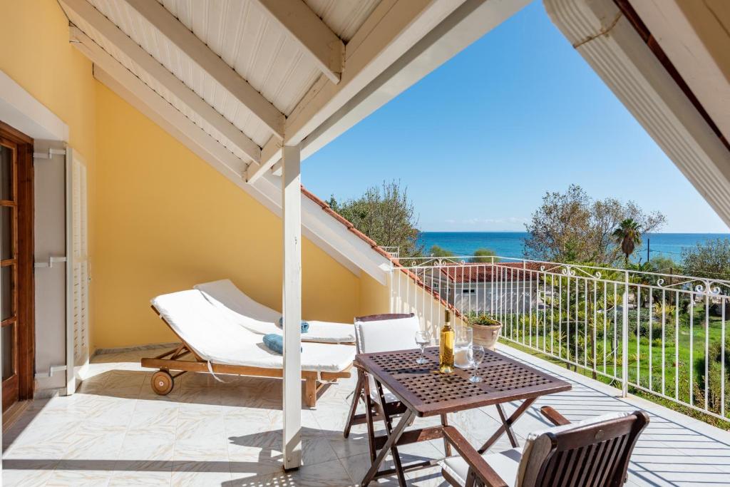 patio con mesa y sillas en el balcón en Albouro Seafront Apartments, en Katelios