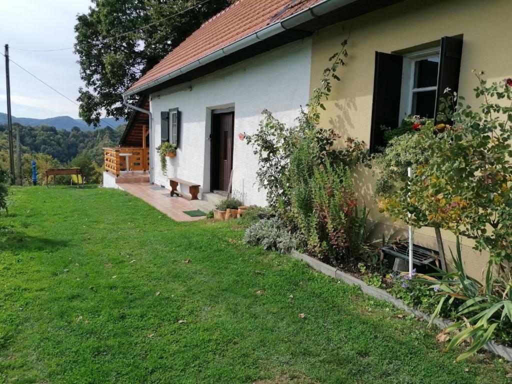 une maison avec un chien assis à l'extérieur dans l'établissement Rural house above the forest, à Gornja Voća