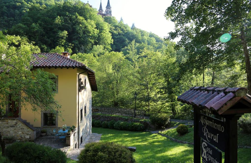 un bâtiment avec un panneau devant une cour dans l'établissement Casa Asprón, à Covadonga