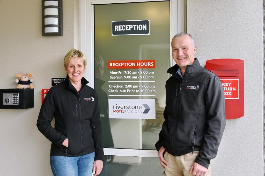 deux hommes debout devant une porte de réception dans l'établissement The Riverstone, à Rangiora