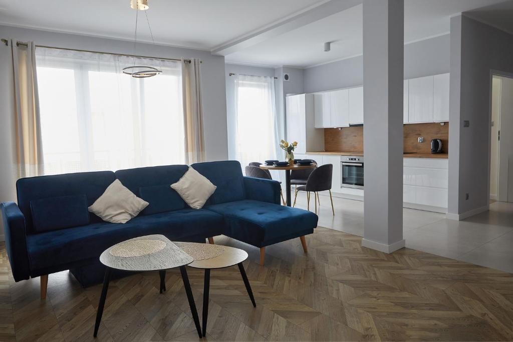 a living room with a blue couch and a table at Przestronny Apartament in Ostrów Wielkopolski