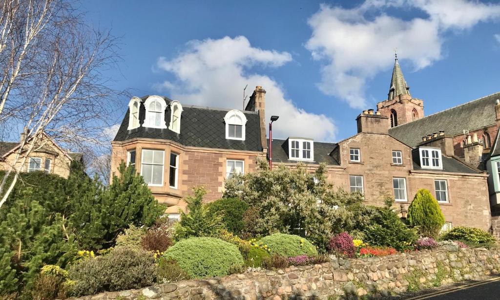 uma antiga casa de tijolos com uma parede de pedra em Leven House Bed and Breakfast em Crieff