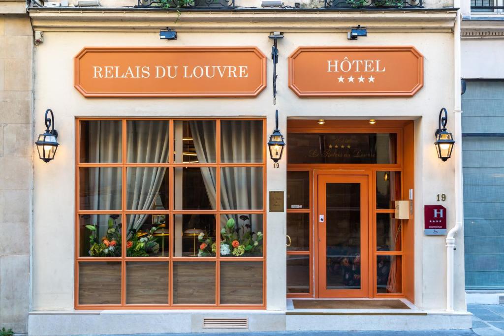 un edificio de hotel con una señal que lee relais du louvre en Relais Du Louvre, en París