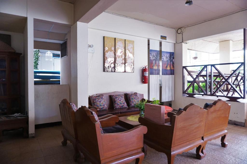 uma sala de estar com duas cadeiras e um sofá em Water Well Guest House em Chiang Mai
