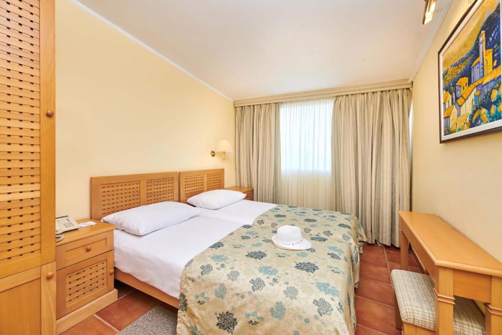 a hotel room with a bed and a desk at Apartments Bellevue Plava Laguna in Poreč