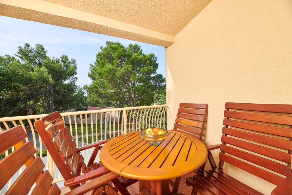 a wooden table and chairs on a balcony at Apartments Bellevue Plava Laguna in Poreč