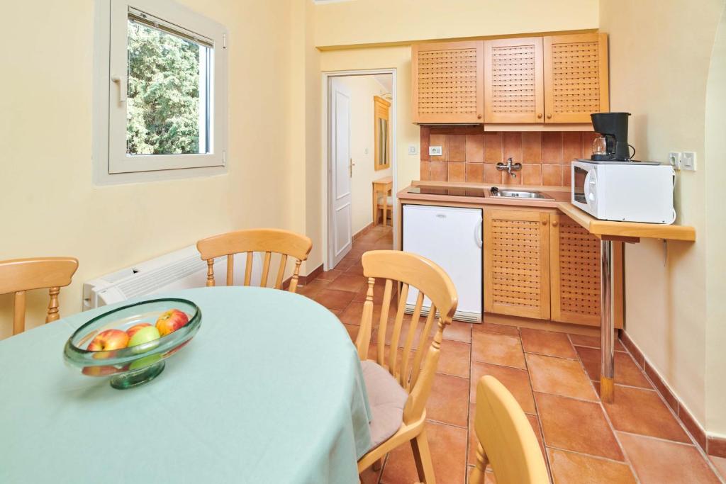 a kitchen and dining room with a table and chairs at Apartments Bellevue Plava Laguna in Poreč