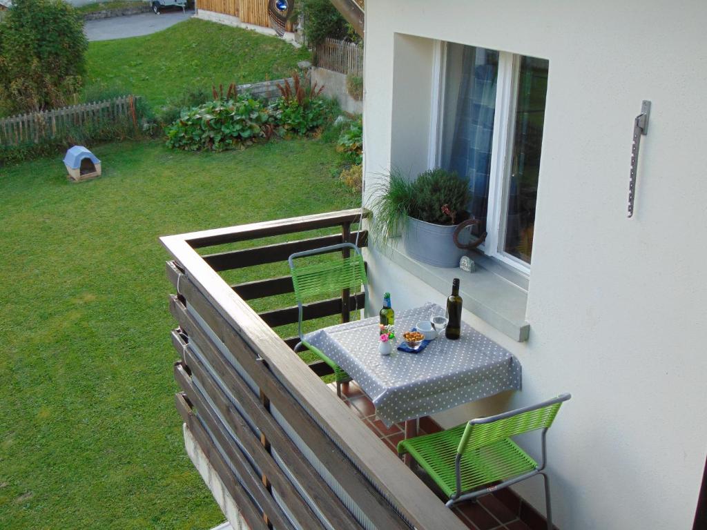 a table and chairs on the balcony of a house at Ferienwohnung Casa Plauns-iu in Sedrun