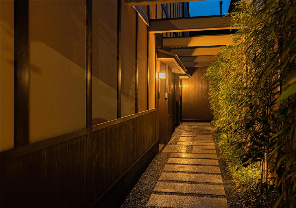 a hallway of a building at night with a plant at 谷町君・星屋・談山旅館　京都嵐山 in Shimo saga